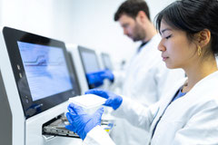 Mitarbeiter einer Biotech-Firma bei der Programmierung einer PCR-Maschine