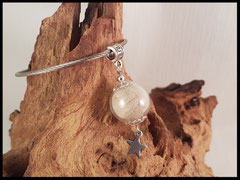 CH 3: Glasperle 16mm gefüllt mit Haaren, silbernen Perlkappen und einen zierlichen Edelstahlstern. Angebracht durch eine Öse an einem Edelstahlring. Preis: 31 Euro