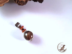 CH 15: 16mm grosse Glasperle gefüllt mit Tierhaar und mit Bernsteinsplitter verziert. Öse aus Edelstahl. Preis: 27 Euro