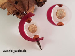 KA 27: Eine Fellperle eingefasst in einem Polarisrahmen eingefasst mit einem Kautschukband. Mit verarbeitet sind 2 Holzperlen. Preis: 30 Euro