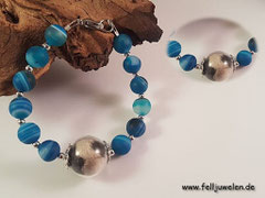 AB 18: Eine gefüllte Glasperle (16mm) mit blauen Achatperlen und zierlichen silbernen Zwischenperlen. Der Verschluss ist aus Edelstahl. Preis: 40 Euro