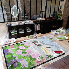 Création de la mosaïque monumentale aux hortensias et hirondelles sur la table de l'atelier.