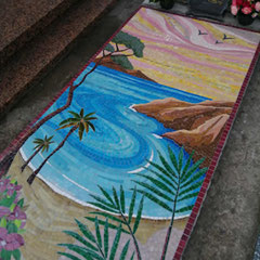 Mosaïque funéraire colorée représentant une  plage avec des pins parasols, rochers et mer bleue sur une pierre tombale au cimetière de Bandol.