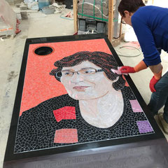 Pose de la mosaïque et application d'un joint époxy sur le portrait funéraire incrusté dans le granit Noir d'Inde, un hommage unique réalisé dans l'atelier  Bourson marbrier pompes funebres à Gouvieux.