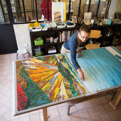 L'artiste mosaïste Toone Nicol en plein travail d'assemblage dans son atelier d'art à Gouvieux, donnant du relief à une mosaïque paysagère