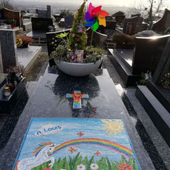 Vue d'ensemble d'un monument funéraire d'enfant en granit labrador bleu  orné d'une plaque et d'une croix en mosaïque artisanale.