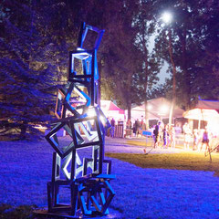 Sculpture en acier éclairée de nuit dans un parc