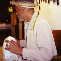 David Hammons holding nappy rock/and nappy hat