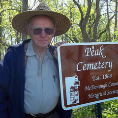 Richard Jackson, genealogist and descendant of relatives resting in the Peak Cemetery, accepts a new sign marking the burial site donated by the McDonough County Historical Society.
