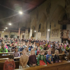 Die vollbesetzte Kirche in Zizenhausen. Vorne sitzen die Schüler. Sie singen ein Lied.