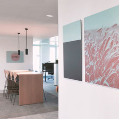 Aufenthaltsbereich im Büro mit moderner Wandkunst und warmem Licht, Kunst im Unternehmen für einladende Räume