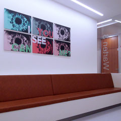 Lounge im Unternehmen mit Sitzbank und Bilderwand aus mehreren Motiven, Kunst für Unternehmen im Wartebereich