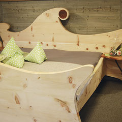 Bett „Waldfee“ aus Zirbenholz mit organisch geformtem Kopf- und Fußteil und Intarsie „Blume des Lebens“