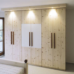Schrank aus Zirbenholz mit weißer Glasauflage auf zwei Türen und Griffleisten aus Nussbaum