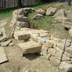 Dry stone retaining wall under construction; stile stones quarried and cut of native sandstone, private client, Kent, Ohio.