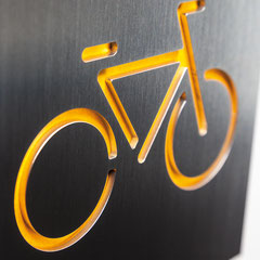 Piktogramm "Fahrradstellplatz" als Konturschnitt in Edelstahl hinterlegt mit farbigem Karton