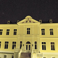 Vorderansocht mit gelber Fassade und großer Freitreppe