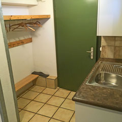 Direkt neben des unteren Eingangs befindet sich eine Kochnische und eine Garderobe - diese Tür führt hinab in den Spielraum