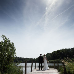 Ein Brautpaar blickt auf den Weiher während des Brautpaar Fotoshootings am Weiherhof in Wächtersbach.