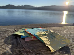 Bild von See im Hintergrund, im Vordergrund bunte Zettel