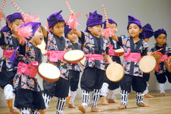 「おでかけがんじゅうタイムIn石垣市」で元気よく演舞する、のびのび保育園の園児=26日午後、市民会館中ホール
