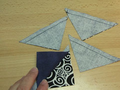 Quadrate dann entlang der beiden Diagonalen durchschneiden.