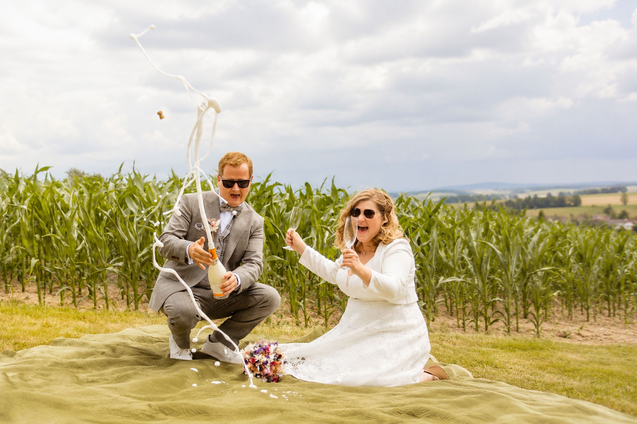 Champagner spritzt - Paarshooting auf der Wiese - Hochzeitsfotograf Herford
