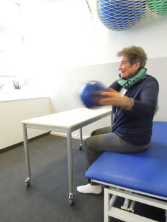 Patientin in Ergotherapie-Praxis bei Übung mit Ball