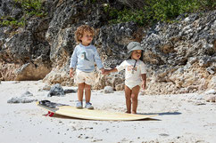 Kinder mit Langarm UV-Shirt auf Surfboard