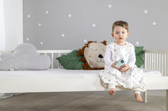 Kind sitzend auf Kinderbett im Schlafanzug to go von Träumeland