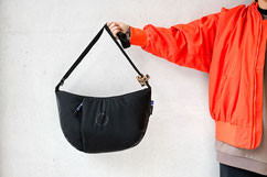 Mutter mit Wickeltasche am ausgestreckten Arm