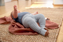 Baby mit Strumpfhose auf Krabbeldecke von LÄSSIG