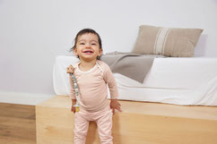 Baby im Schlafanzug mit angeclipter Schnullerkette von LÄSSIG