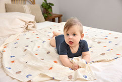 Baby mit Body auf Krabbeldecke 
