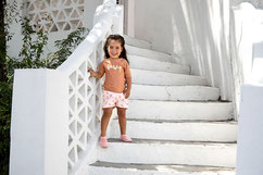 Mädchen mit Badeshorts auf einer Treppe