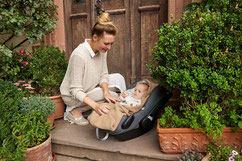 Mami mit Kind in Babyschale und Einschlagdecke Cosy Bag