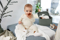 Baby mit Schnuller auf Wickeltisch mit Wickelorganizer
