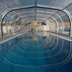 High, flat telescopic swimming pool enclosure motorised with AKIA wheeled motor drives