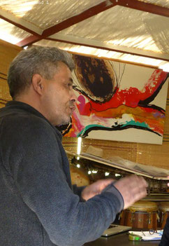 Un homme marocain et un tableau avec peintures vives en fond