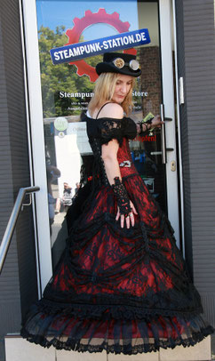Edles Steampunk-Damen-Outfit mit weitem Reifrock, engem Korsett und verzierten Zylinder-Hut.