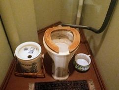 Historic water closet flanked by old bidet and chamber pot in Riga Art Nouveau Museum