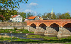 Old red brick bridge and historic houses in Kuldīga, Latvia