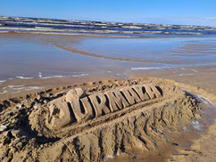 Sand sculpture with the word "Jurmala" on the beach in Latvia