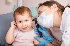 un medecin examine l oreille d un bebe