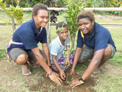OISCA trainees support students when planting tree