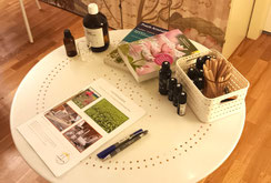 Tisch mit ätherischen Ölen, Fachbüchern und Skript für Workshop