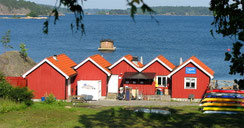 Typische skandinavische Holzhütten am Ufer eines der Inseln im Schärengarten vor Stockholm.