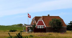 Sehenswürdigkeiten Dänemark: Ein typisches dänisches Haus mit einem gehissten Danebrog, der dänischen Nationalflagge.