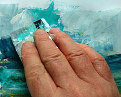 Hand mit Spachtel am Landschaftsbild