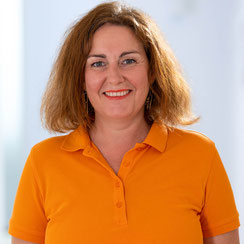 Porträt von Mitarbeiterin im orange-farbigen Poloshirt